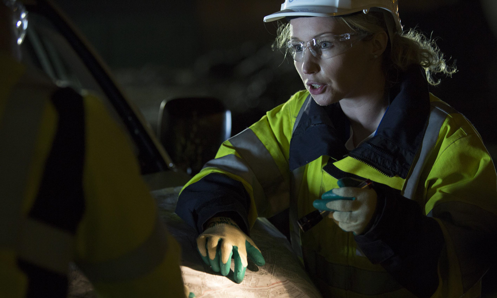 two uisce eireann engineers discussing something at night time