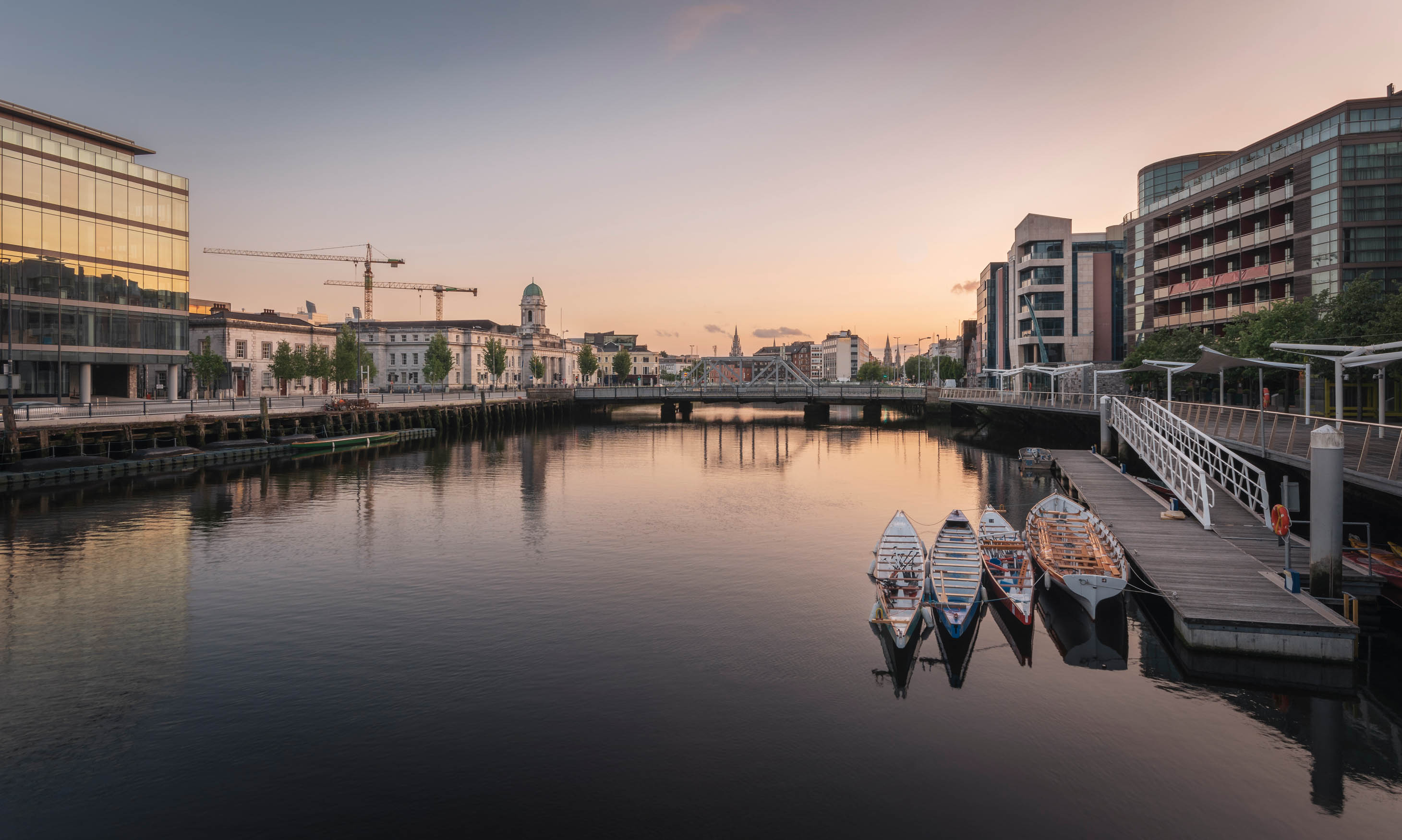 Deck and several small boats on a river in a city
