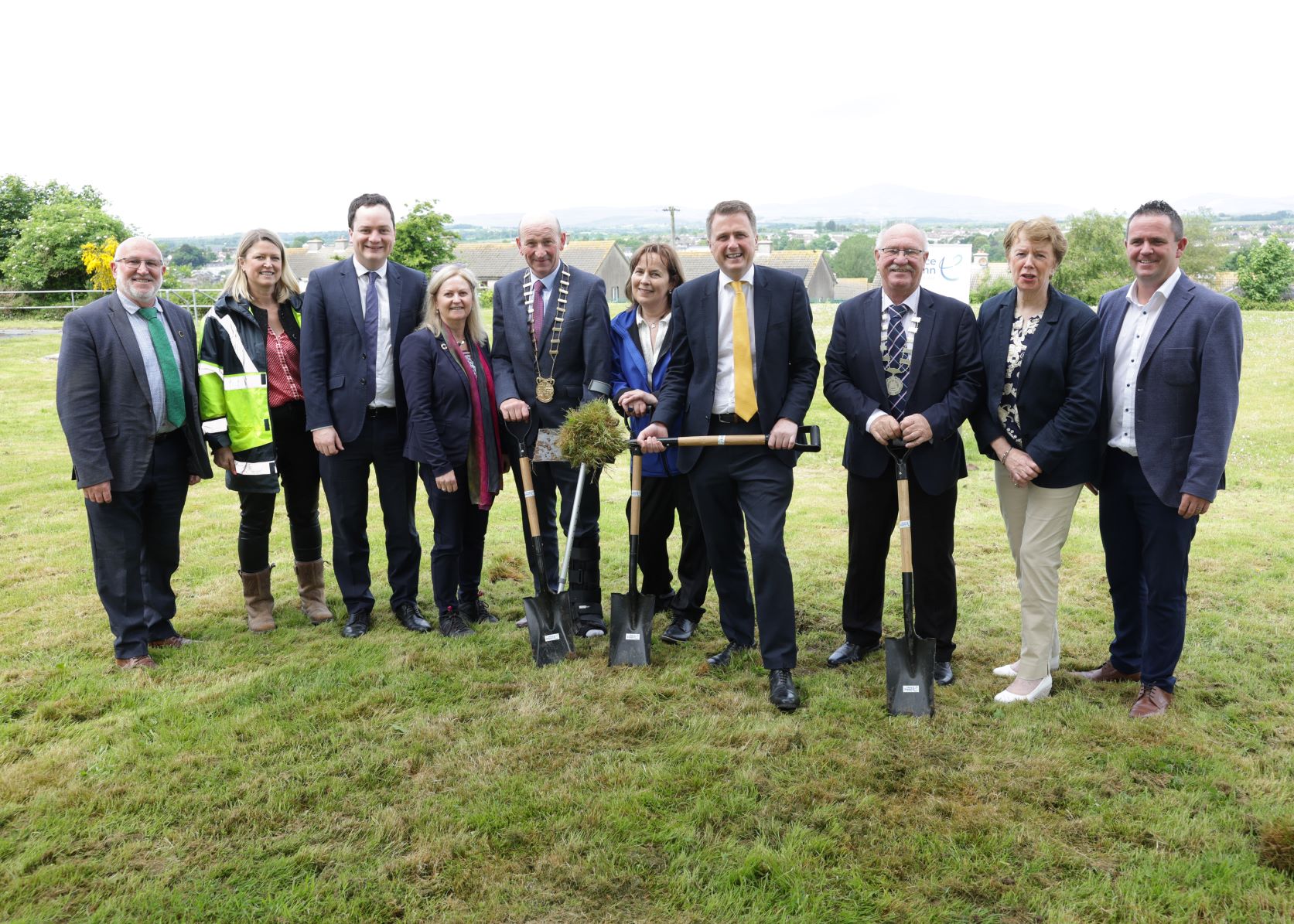 A group of people  with shovels smiling at the camera