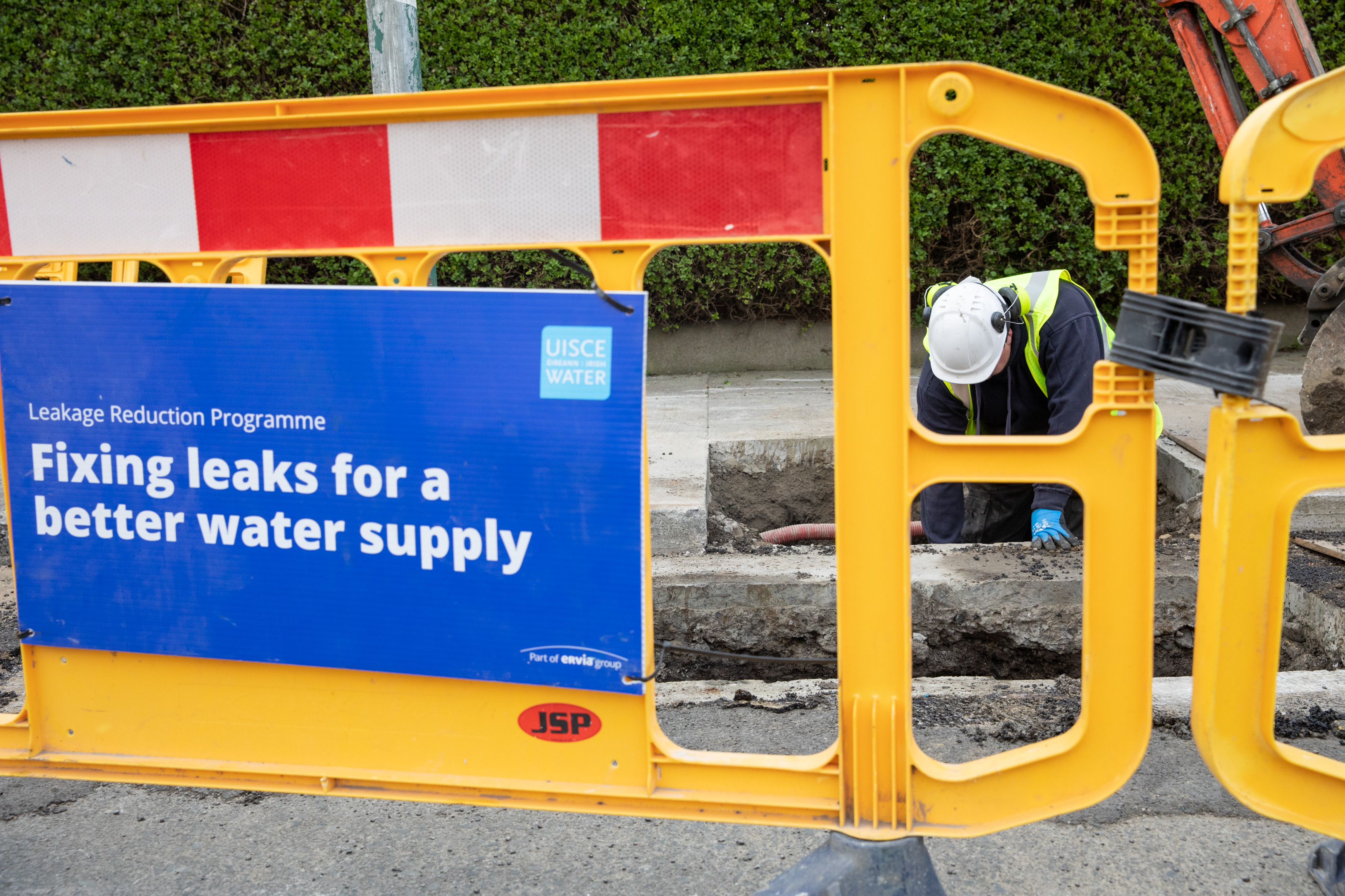 An Uisce Éireann worker fixing a pipe in the ground