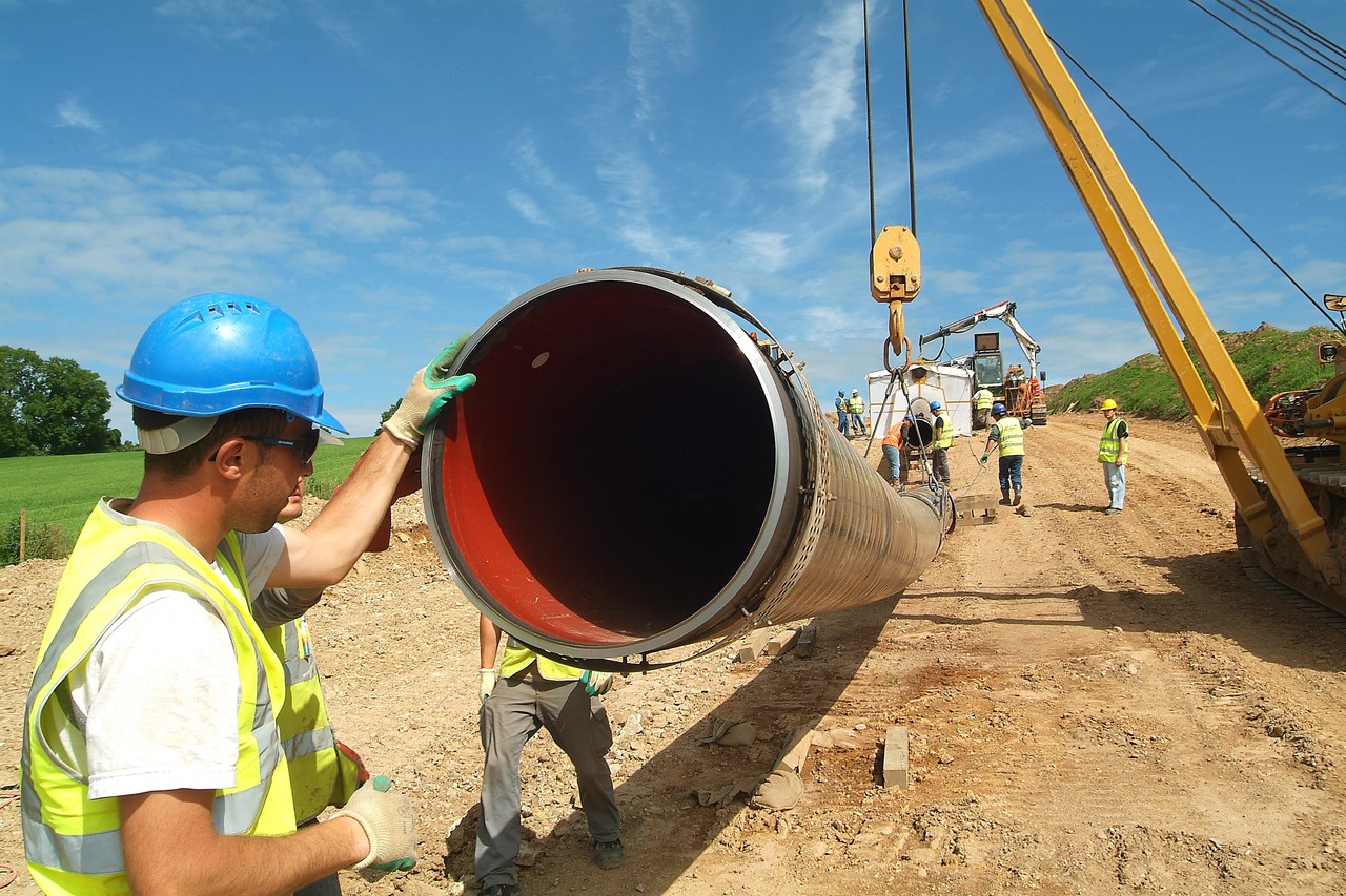 Uisce Éireann workers working with a large pipe on a construction site