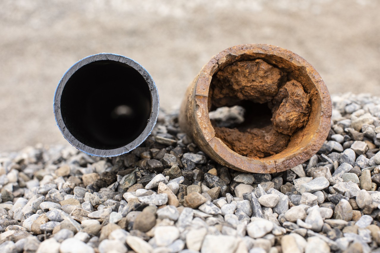 A new clean pipe next to an old damaged and rusty pipe