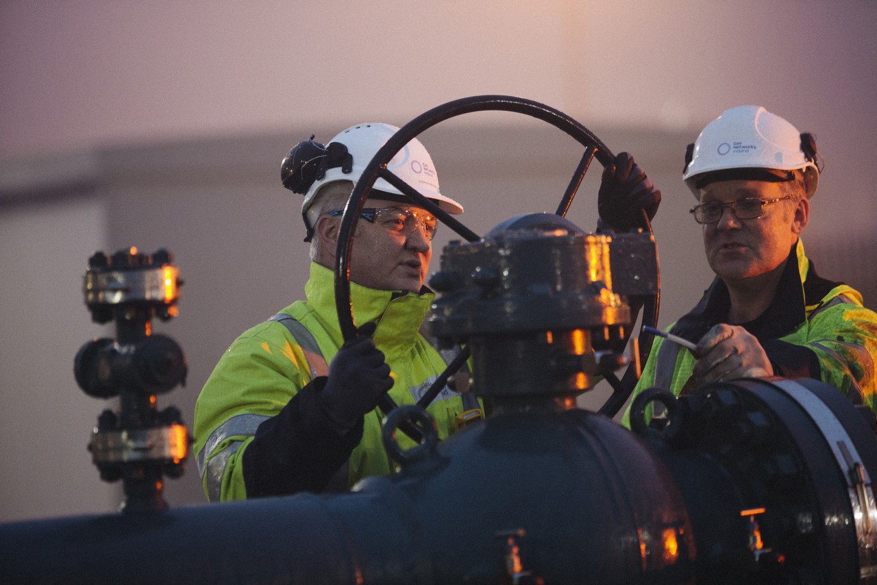 Workers turning a wheel on a pipe