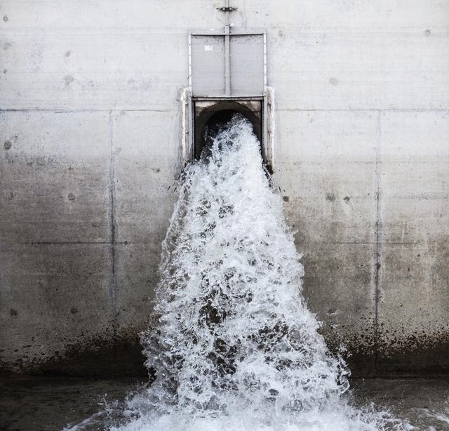 Water flowing out of a large pipe in a wall