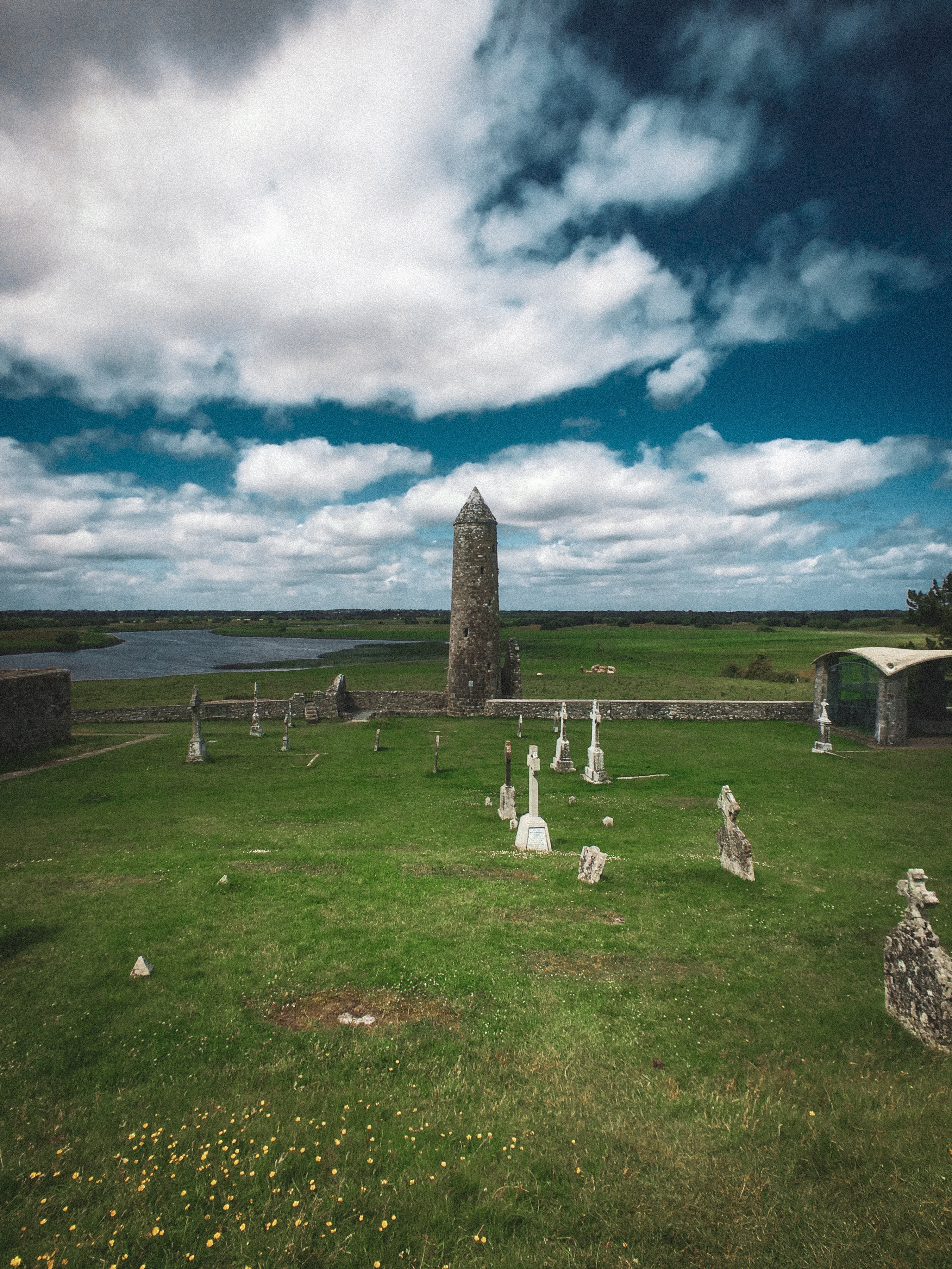 Graveyard with a round tower beside a lake