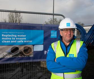 An Uisce Éireann worker standing in front of a LRP banner