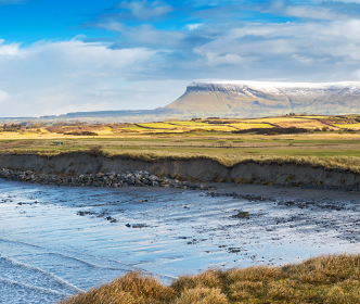 A person walking on a beach at Rosses Point