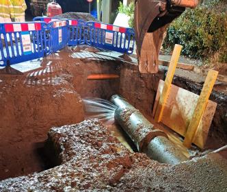 A large burst pipe in the ground on a site