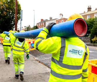 Uisce Éireann workers carrying a pipe