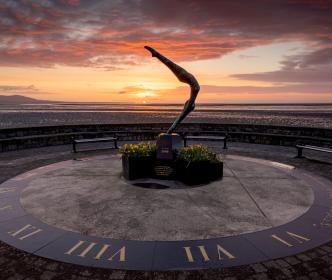 The sun setting behind a sundial in Blackrock Village